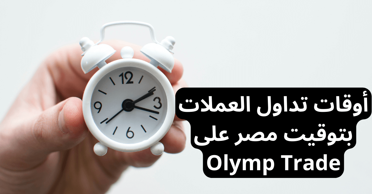 أوقات تداول العملات بتوقيت مصر على Olymp Trade أمامها يد رجل تحمل منبه أبيض و صغير و قديم خلفية رمادية